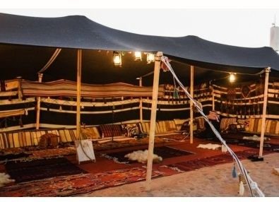 Desert camp majlis and stage at dusk